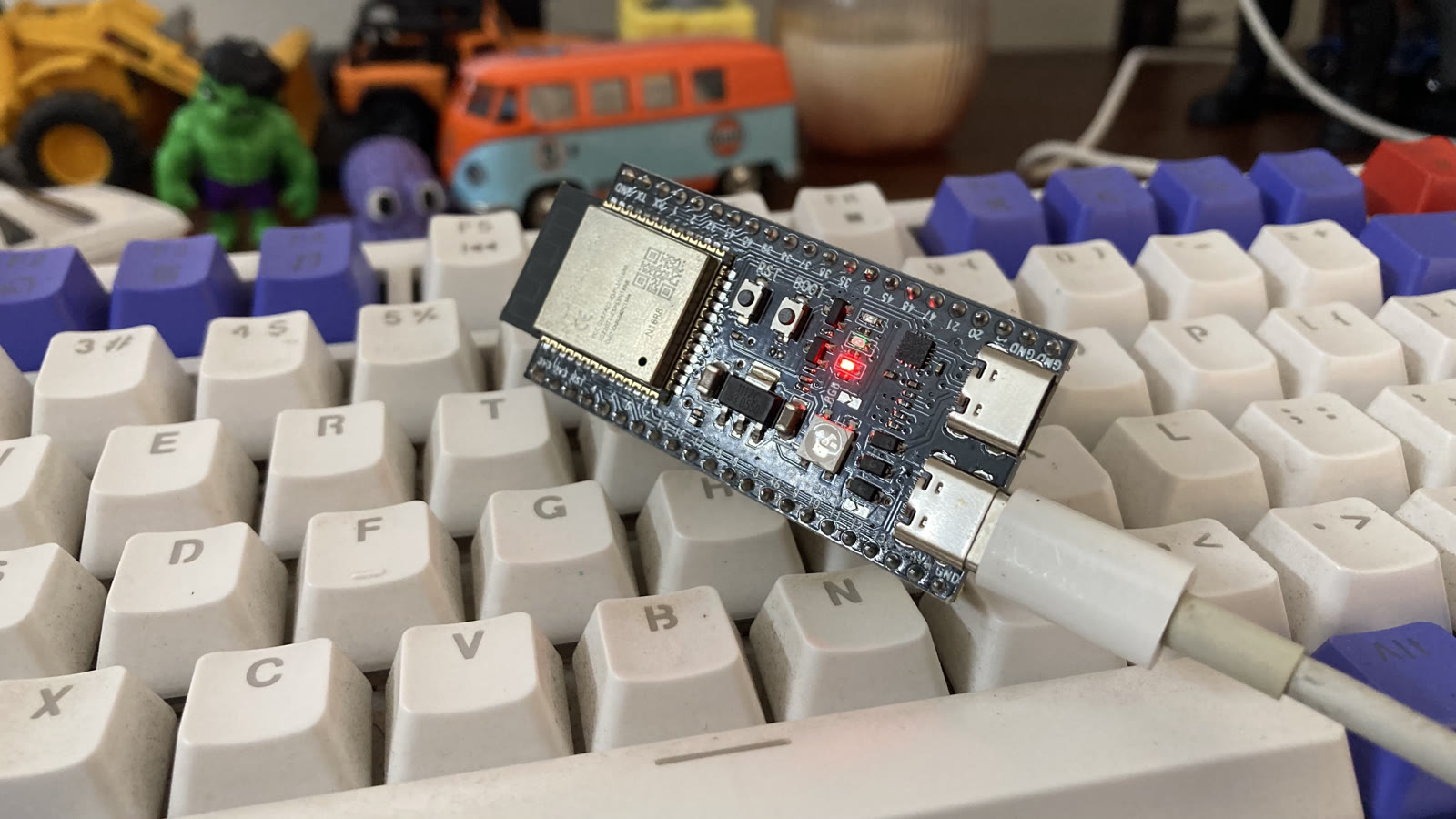 ESP32-S3-DevKitC-1 N16R8 board on a keyboard, USB-C connected, running the Whistle speech-to-text model